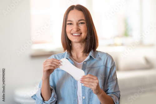 Happy young woman holds daily cotton pad posing at home