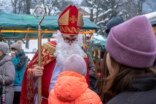 Saint Nicholas gives sweets to children at the Christmas market