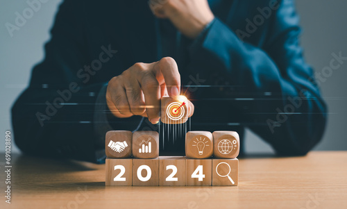 Businessman setup business trend 2024 strategy action target, Start calendar 2024 plan concept. Person Goal challenge person planning growth New year 2024, profit income, digital marketing.