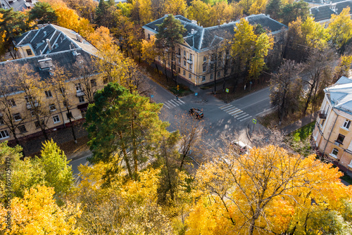 View from above of bright autumn city streets in a residential area. Uncontrolled intersection with light traffic