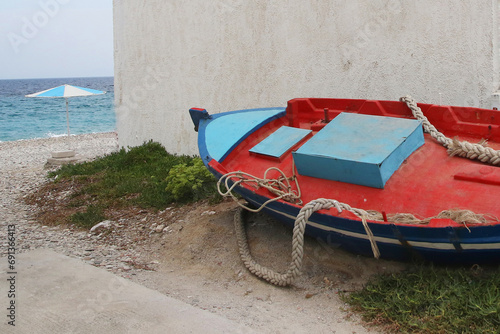 Red and blue traditional fishing boat on the beach in Kokkkari village on the greek island of Samos
