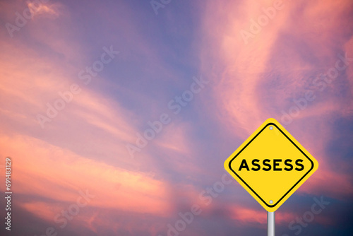 Yellow transportation sign with word assess on violet color sky background