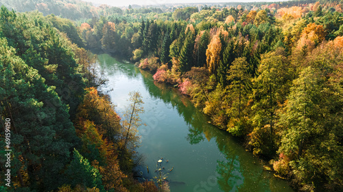 River Brda and colorful forest at sunrise in autumn, Poland.
