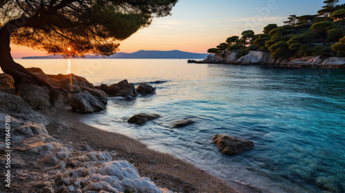Greece, at sunset. The focus is on the crystal-clear waters and golden sands, framed by olive trees