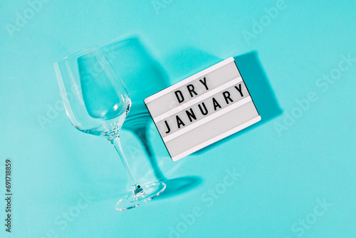 Text Dry January on the decorative lightbox and empty wine glass isolated on blue background