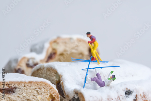 Skier on a Christmas cake, miniature figures scene with the theme, sports accident during the Christmas holidays