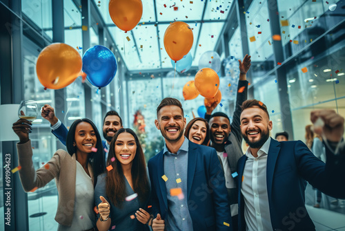 Group of young confident successful business people with balloons celebrating achievement. Business event or party at office hall.