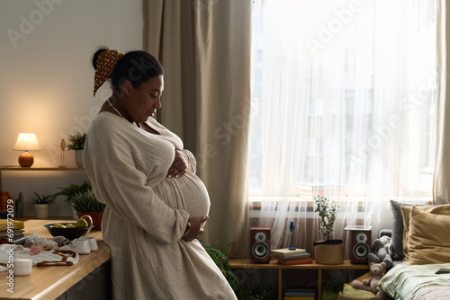 African American pregnant woman stroking her belly and expecting her child