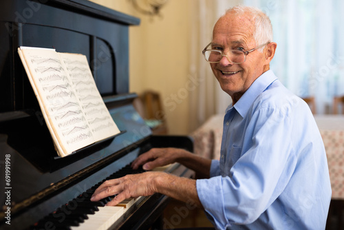 Old man playing piano at home