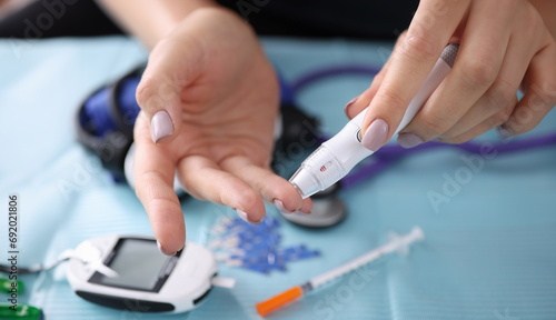Woman drawing blood with lancet at home closeup. Blood glucose control in diabetes mellitus concept