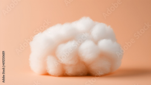 A fluffy white cotton ball on peach fuzz color minimal background. Modern trendy tone hue shade
