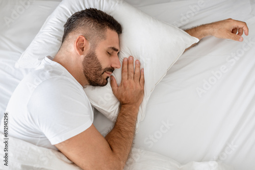 Caucasian man lying in comfy bed taking peaceful nap indoor