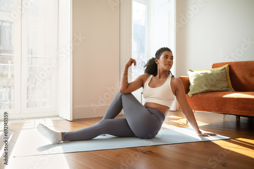 fitness woman practicing yoga doing seated spinal twists indoor
