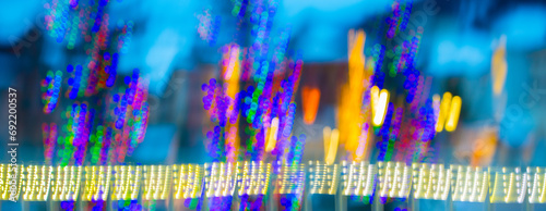 abstract blur of colorful christmas lights with vertical motion blur special effect created by long time exposure and intentional camera movement celebratory lights going in up and down direction