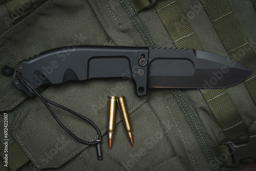 Large folding tactical survival knife and rifle ammo.