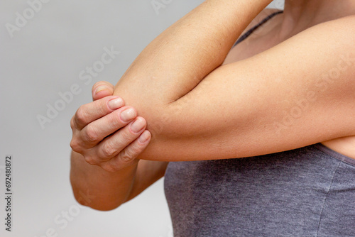 Woman hands joint pain in elbow over cropped body