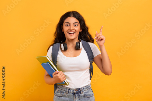 Excited young eastern lady student raising finger up