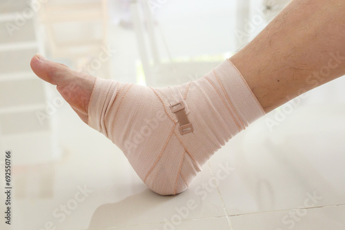 Man with ankle sprain elastic bandage for ankle injury and feeling pain