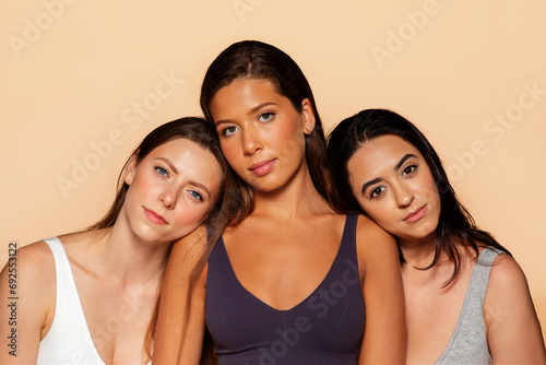 Calm three young international women with serene expressions, rest, looking at camera