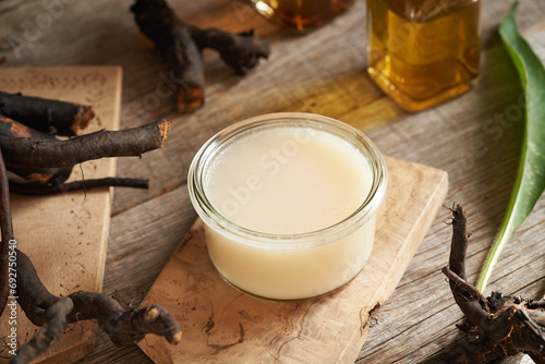 A jar of homemade comfrey ointment made of rendered pork lard and fresh root