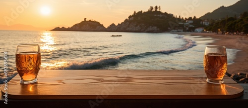 Sunset view of wooden bar item in Sveti Stefan, Adriatic Sea. Water surface reflects sun beam. Summer vacation by the seaside.