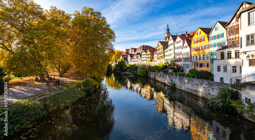 Panoramic view of famous historic facades of old town of Tuebingen on Neckar River in southern Germany. Autumn season atmosphere with colorful foliage, Hölderlin tower and church. Sunny blue sky day.