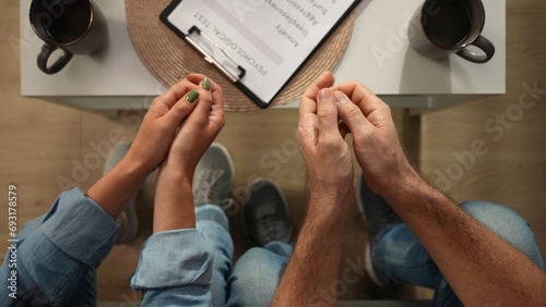 Top view of married couple at the therapy session. Close up shot of hands, man and woman sitting on the sofa.