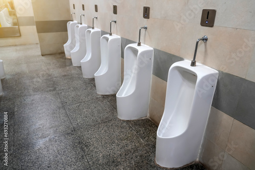 Empty row of outdoor urinals men public toilet. White ceramic urinals for man in toilet room. Gentlemen restroom in the restaurant. Interior men's toilet.