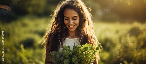 Attractive young woman holds herbs outdoors, close-up.