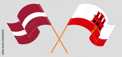 Crossed and waving flags of Latvia and Gibraltar