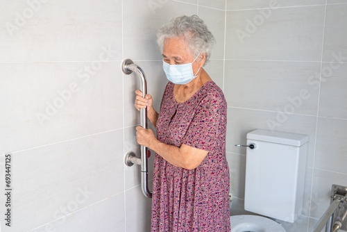 Asian senior woman patient use toilet bathroom handle security in nursing hospital, healthy strong medical concept.