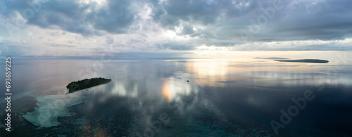 A serene sunrise illuminates the remote island of Koon near Seram, Indonesia. This scenic island's coral reefs, and the surrounding seas, support extraordinary marine biodiversity.