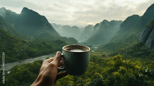 A hand extends with a cup of coffee, overlooking a lush valley with mist-veiled mountains, capturing the essence of a serene morning retreat...