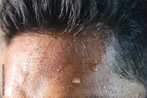 closeup of sweat on forehead against dark background ,