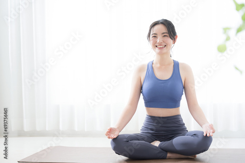 Young woman doing yoga, looking at the camera