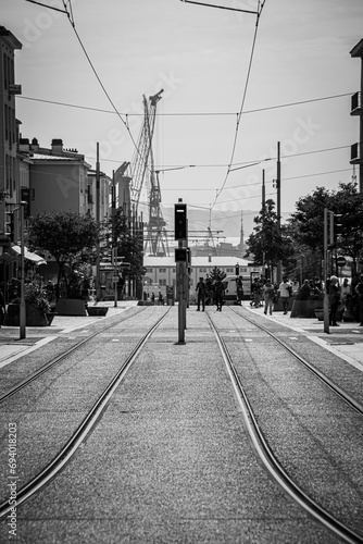 Train tracksBrest railway with port in the background going down pedestrian avenue promenade rambla street black and white bw