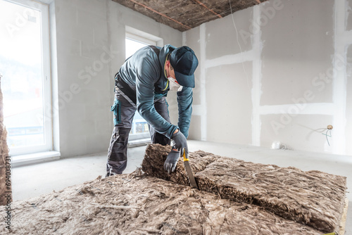 Ceiling insulation. Cutting a thermal insulation from glass wool using a knife for stone wool. iling thermal insulation.