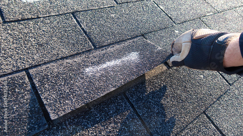 Residential roof inspection for an insurance claim due to storm damage. The asphalt shingles show signs of damage. 