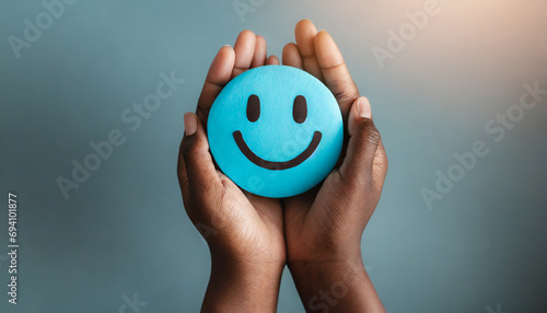 Hands holding blue happy smile face. mental health positive thinking and growth mindset, mental health care recovery to happiness emotion.
