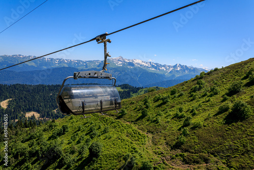 Carousel cable car in the mountains, green mountains on a sunny