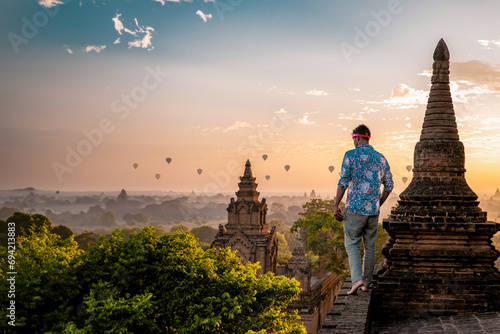 Bagan Myanmar, young men looking at the sunrise on top of an old pagoda temple. a European man on vacation in Myanmar Asia visit the historical site of Bagan