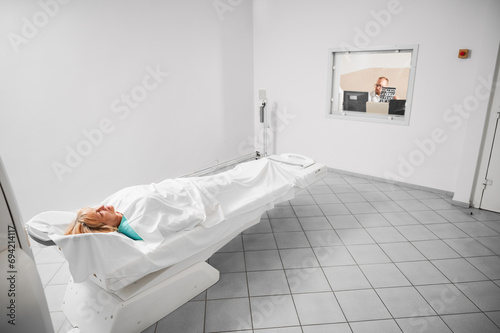 Medical computed tomography or MRI scanner. Female patient lying on couchette while doctor making MRI in clinic. Concept of modern diagnostics.