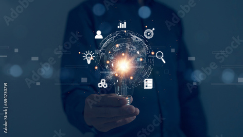 Businessman's hand holds a light bulb, global business internet connection application technology digital marketing Finance and digital link technology big data