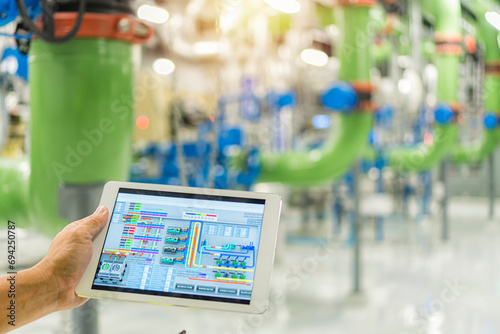 person holding a tablet computer on chiller Plant background