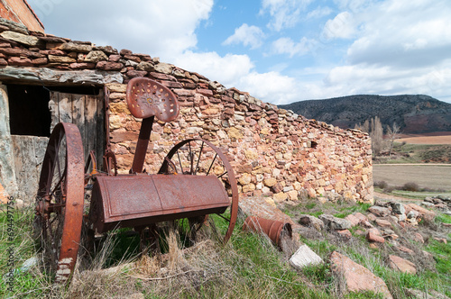 Paisaje rural de la España vaciada o despoblada con un antiguo apero de labranza abandonado.