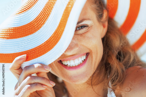 happy young woman in swimsuit and beach hat
