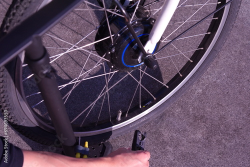 自転車のタイヤに空気を入れているタイヤと手元の写真。自転車のメンテナンスや大切に扱っている様子をイメージ。