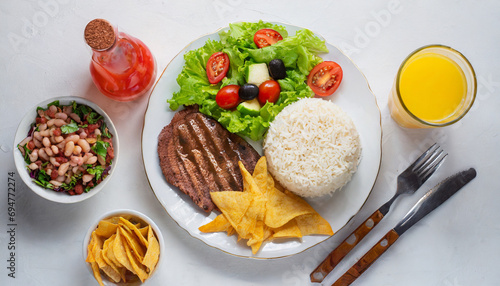 Top view de refeição tipo prato feito com: arroz, feijão, bife e salada