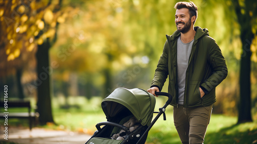 Adult man or father with stroller or perambulator in the city park with green grass on a sunny autumn day. Young dad parent walking and pushing baby carriage or pushchair with teddy bear