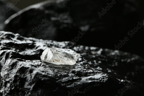 Shiny rough diamond on stone surface. Space for text